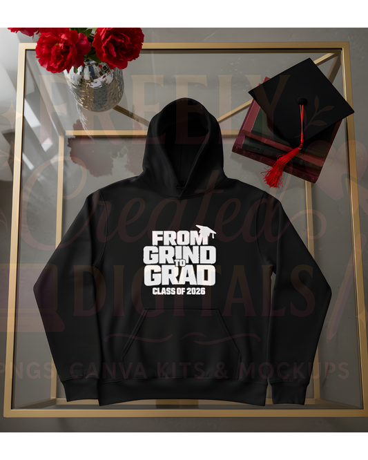 Black hoodie with 'From Grind to Grad Class of 2023' text, graduation cap, and flowers on a glass surface.